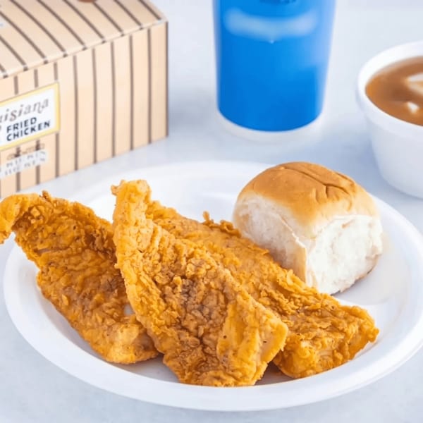 Louisiana Fried Chicken meal with three chicken tenders, a bun, gravy, and a blue drink.